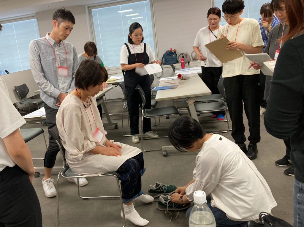 養成講座の対面実技講習で靴のフィッティング指導を受ける様子